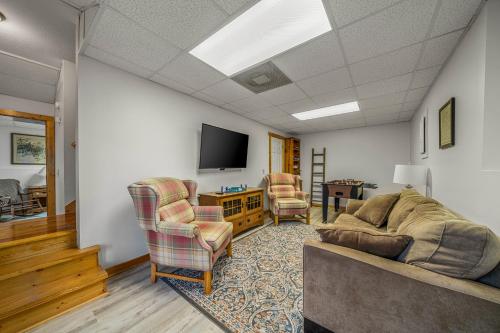 a living room with a couch and chairs and a tv at Creeksong in Ellijay