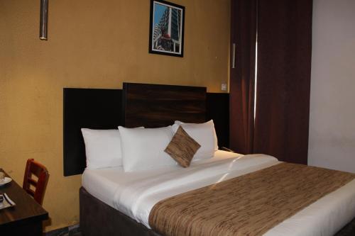 a hotel room with a large bed with white pillows at Residency Hotel Lekki Chevron in Lekki