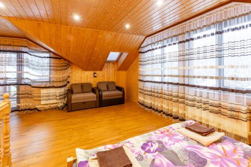 a room with a bed and two chairs in it at Karpasole in Tatariv