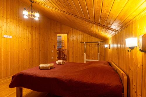 a bedroom with a large bed in a wooden room at Karpasole in Tatariv