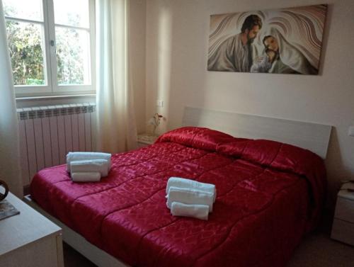 a bedroom with a red bed with two pillows on it at Casa delle Rose in Fiumaretta di Ameglia