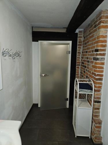 a hallway with a door and a chair next to a brick wall at Haus mit 4 Ferienwohnungen am Fuselpättken in Sendenhorst