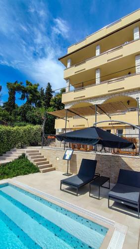 a hotel with a swimming pool next to a building at Villa Penava, private beach, pool and 7min to Trogir in Trogir