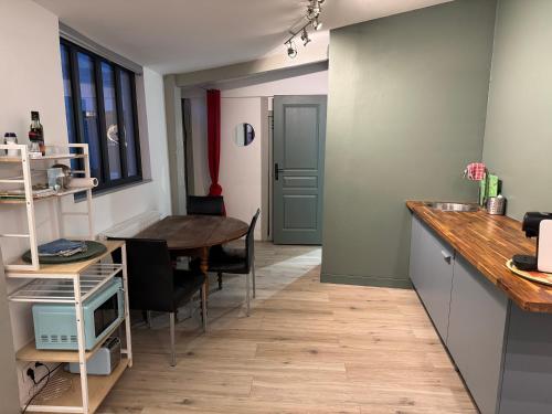 une cuisine avec une table et une salle à manger dans l'établissement Petite maison indépendante avec parking, à Vétheuil