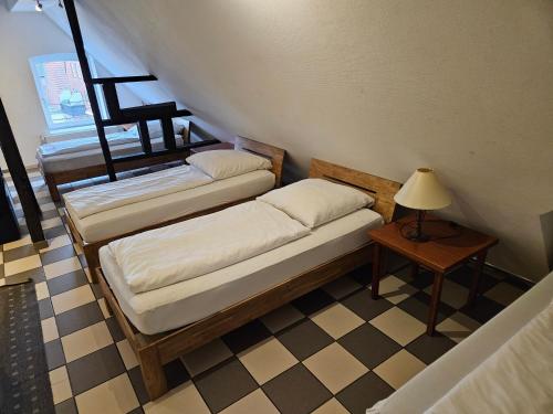 two beds in a room with a lamp and a table at Haus mit 4 Ferienwohnungen am Fuselpättken in Sendenhorst
