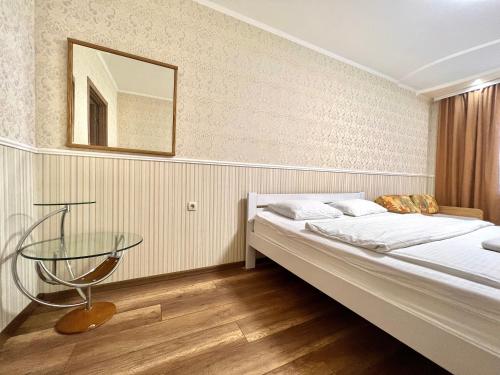 a bedroom with a bed and a glass table at ApartPoltava 100 квадратних метрів затишку в серці Полтави, Корпусний парк, Банківський ЧЕК in Poltava