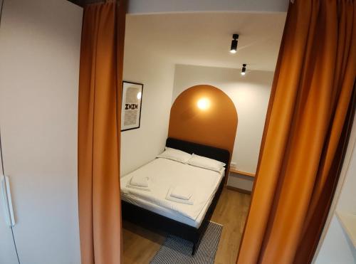 a small bed in a small room with an orange curtain at Christians Haus in Târgu-Mureş