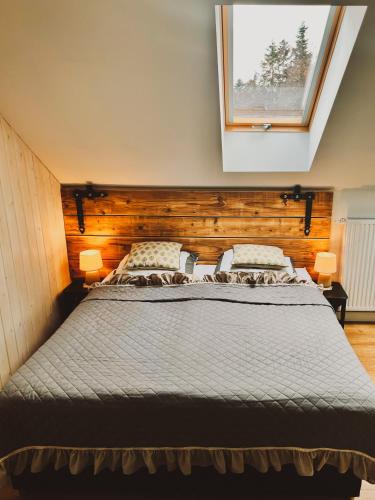 a bedroom with a large bed and a window at Zagroda na Pacanach in Iwkowa