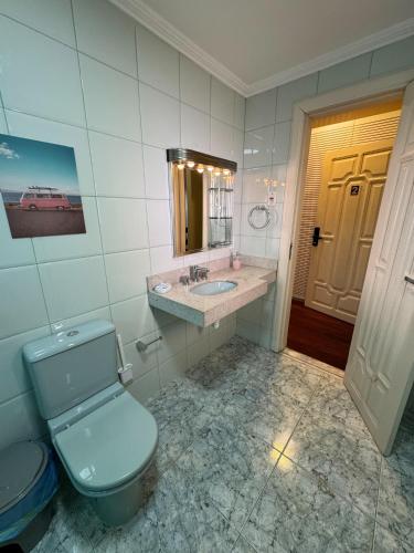 a bathroom with a toilet and a sink and a mirror at Casa Rosa Suítes 5 min de caminhada da PRAIA DA PONTA NGRA in Manaus