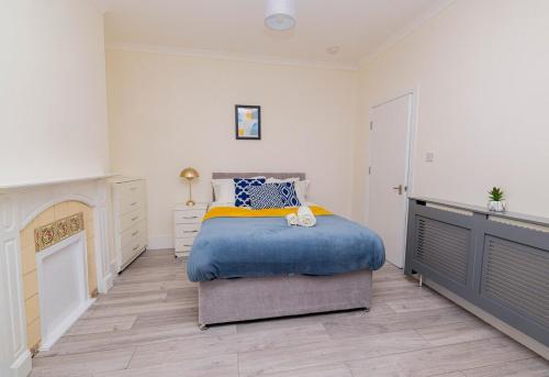 a bedroom with a bed with a blue comforter at 4-bed house in Kettering for groups and long stays in Kettering