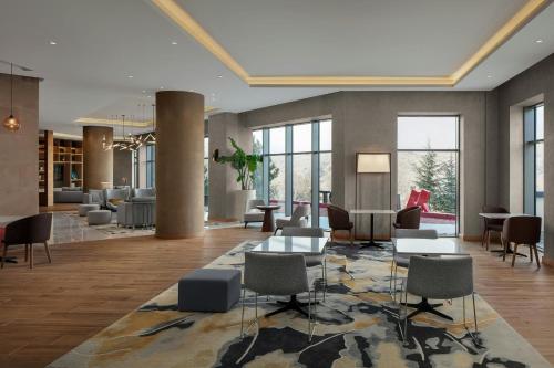 a lobby with tables and chairs in a building at Cappadocia Marriott Hotel in Nevsehir