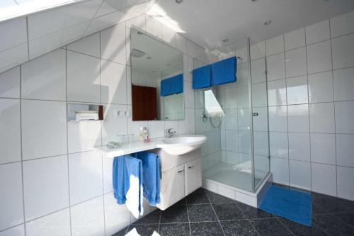 a white bathroom with a sink and a shower at Felshof - Weingut & Gästehaus in Sommerhausen