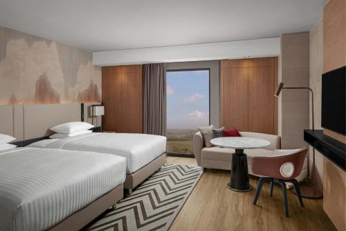 a hotel room with two beds and a couch at Cappadocia Marriott Hotel in Nevsehir