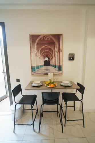 a dining room table with chairs and a painting on the wall at Emplacement Central Lumineux & Chic Prés de Station Tramway KFC Et Carrefour Abdelmoumen Et 2 Mars Casablanca in Casablanca