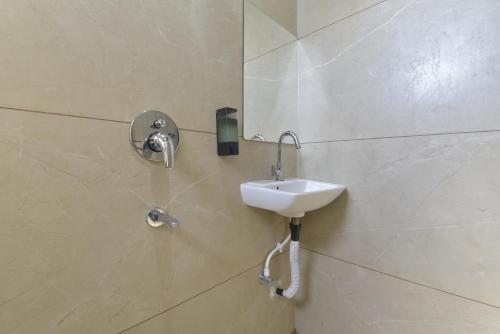 a bathroom with a sink and a mirror on the wall at Hotel Vilaasitaa inn Ujjain in Ujjain