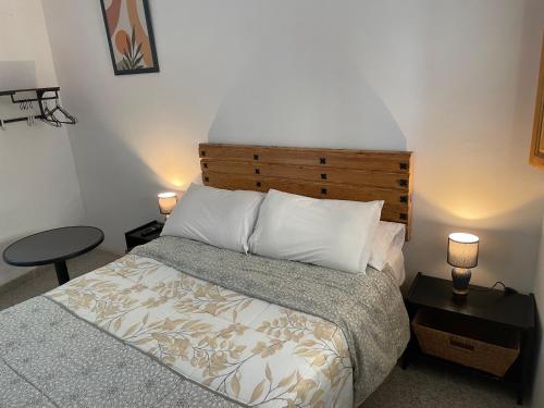 a bedroom with a bed and a table and two lamps at Habitación independiente 2 en casa particular in Utrera