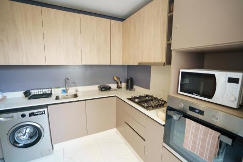 a kitchen with a washing machine and a microwave at Emplacement Central Lumineux & Chic Prés de Station Tramway KFC Et Carrefour Abdelmoumen Et 2 Mars Casablanca in Casablanca