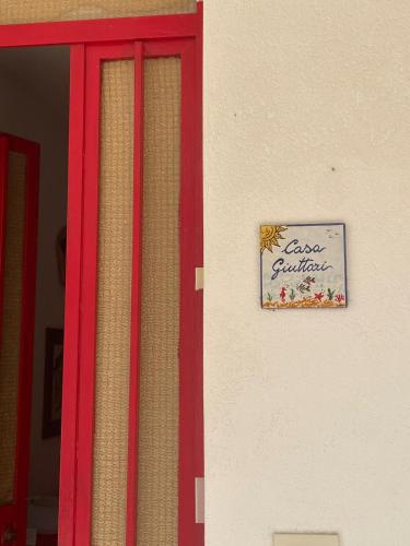 a sign on the side of a building with a window at San Giorgio (Me) Comodo appartamento a 100 metri dal mare in elegante residence, 4/5 posti letto, parcheggio privato. in San Giorgio