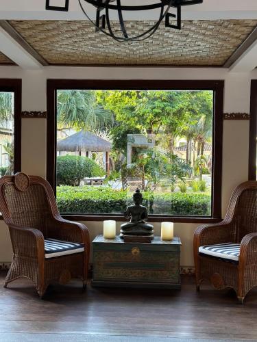 a living room with two chairs and a table with candles at Pousada Corsario Buzios in Búzios