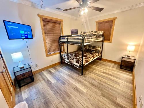 a room with two bunk beds and a flat screen tv at Sleeps 22, mountain view, game room, pet friendly! in Sevierville