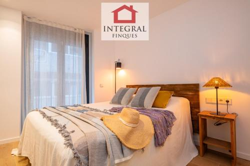 a bedroom with a bed with a hat on it at Apartament Bella Terra in Palamós