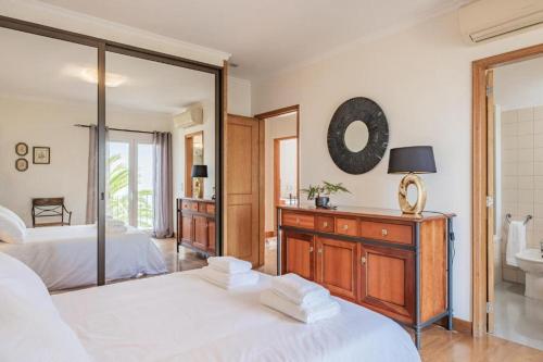a bedroom with two beds and a mirror at Palmeira`s Village in São Gonçalo