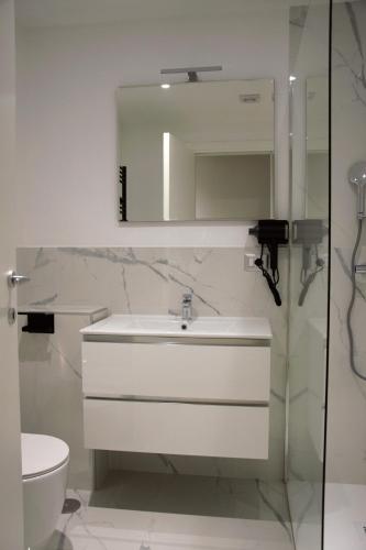 a bathroom with a sink and a mirror and a toilet at Domus Dea Roma by Trinità in Rome