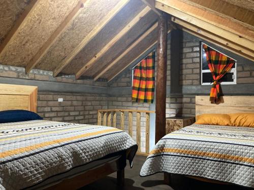 a bedroom with two beds in a wooden cabin at Cabañas los Álamos 2 Creel in Creel