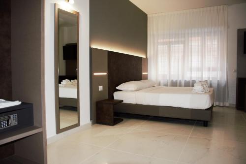 a bedroom with a bed and a large mirror at Domus Dea Roma by Trinità in Rome