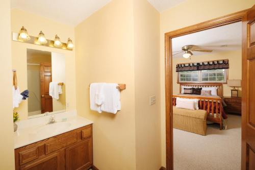 a bathroom with a sink and a mirror and a bedroom at 3BR with mtn view and hot tub in Wears Valley! in Sevierville