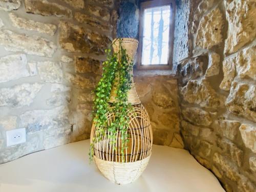 a wicker vase sitting on a table next to a brick wall at Le PARC DE LA TRICHERIE in Onet le Château