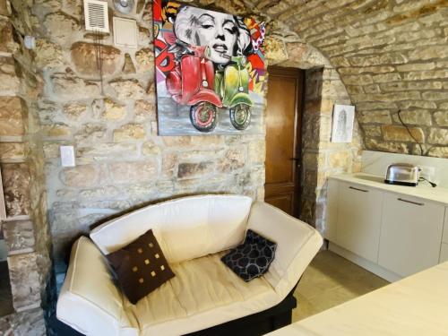 a white couch in a room with a stone wall at Le PARC DE LA TRICHERIE in Onet le Château