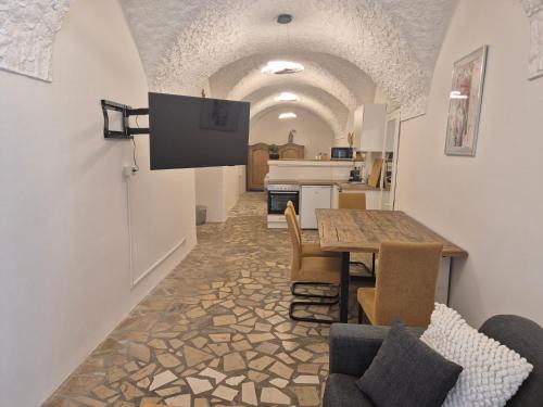 Una cocina y un comedor con mesa y sillas. en Charmantes Brauerei-Altstadtgewölbe, en Laufen