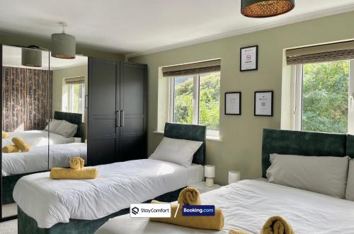 カンタベリーにあるFive Bedroom House By StayComfort Short Lets & Serviced Accommodation Canterbury With Garden & Parkingのベッドが2つと窓が2つある寝室