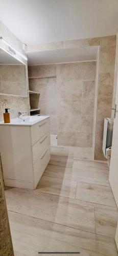 La salle de bains est pourvue d'un lavabo blanc et d'un comptoir. dans l'établissement Le Cocon de ville sètois, Clim, patio et garage pour véhicule type golf, Linge de lit et serviettes inclus, à Sète