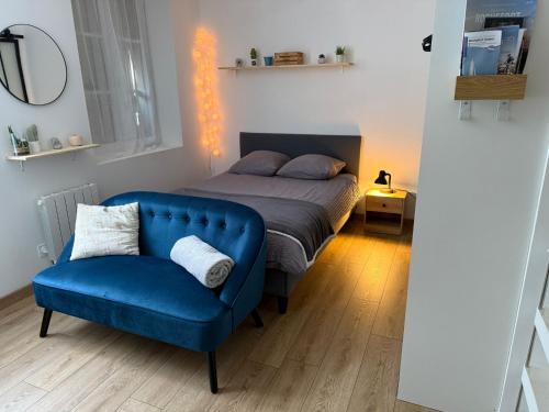 une chambre avec un lit et un canapé bleu dans l'établissement Le Cosy, à Rochefort