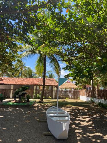 a toilet sitting in a yard under a tree at Amaly Pousada e Bistrô in Japaratinga