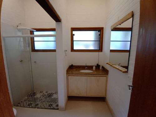 ein kleines Badezimmer mit Waschbecken und Dusche in der Unterkunft Casa ecológica, cheia de conforto, em reserva agroecológica in Espirito Santo Do Pinhal