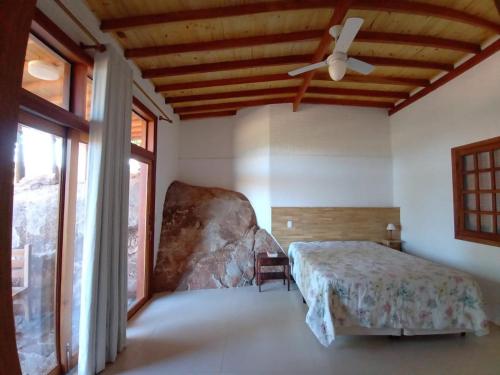 ein Schlafzimmer mit einem Bett und einem Deckenventilator in der Unterkunft Casa ecológica, cheia de conforto, em reserva agroecológica in Espirito Santo Do Pinhal