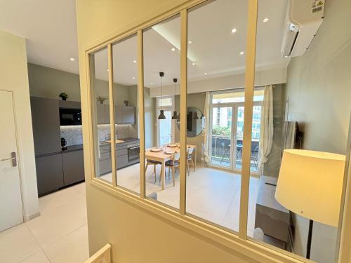 une cuisine et une salle à manger avec une table et des baies vitrées dans l'établissement NICE La Palmeraie Pool BEACH AC, à Nice