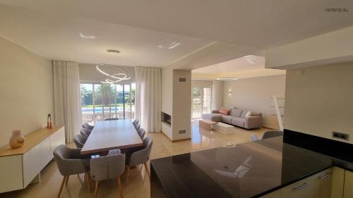 a kitchen and living room with a table and chairs at Pestana Carvoeiro Golfe - AL in Carvoeiro