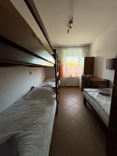 a room with two bunk beds and a window at Vámház Vendégház in Pápa