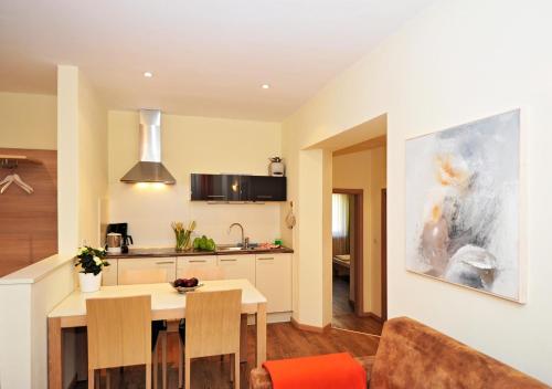 a kitchen and living room with a table and chairs at Residence Mignon in Rifiano