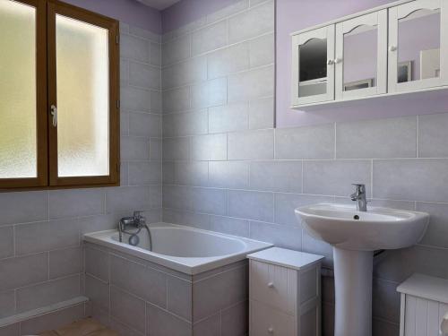 ein weißes Badezimmer mit Waschbecken und Badewanne in der Unterkunft Maison spacieuse et fonctionnelle - 5 chambres, terrasse, parking privé - FR-1-548-27 in Villard-de-Lans