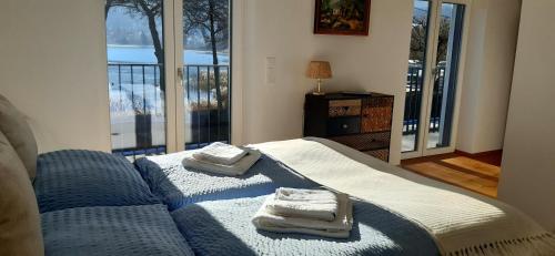 una camera da letto con due asciugamani su un letto con finestra di Lakesideview Keutschach am See a Keutschach am See
