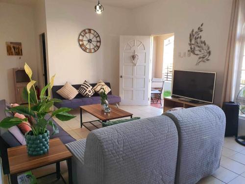 a living room with a couch and a tv at Panglao Staycation Home in Dauis
