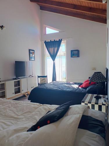 a bedroom with two beds and a window at Carabelli Propiedades in Río Grande