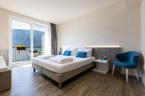 a bedroom with a bed and a blue chair at Hotel Oasi Beach in Malcesine