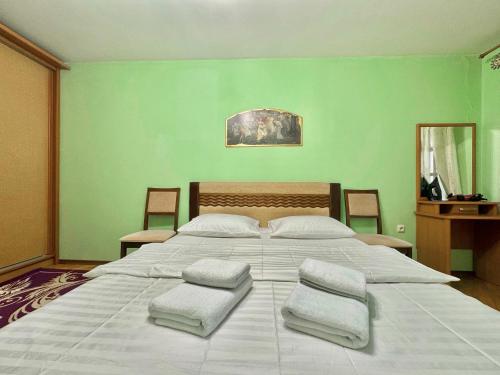 una camera da letto con un grande letto bianco con tre cuscini di ApartPoltava Затишна 3-кімнатна квартира в центрі міста, КАШТАНОВА АЛЕЯ, звітна документація, ЧЕК a Poltava