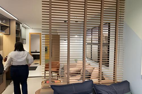 a woman standing in a kitchen looking at a living room at Refúgio carioca com piscina in Rio de Janeiro